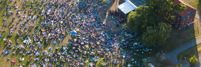 Südstadtpark mit Musikschulgebäude von oben, Menschen picknicken bei einem Open Air Konzert