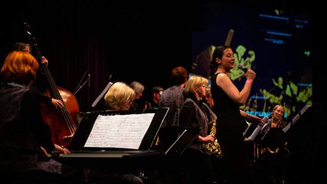 Sängerin im langen schwarzen Kleid und Big Band