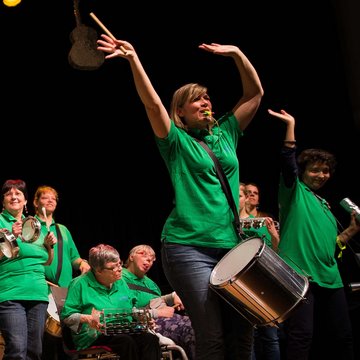 Die Fürther Sambias mit gründen T-Shirts, im Vordergrund die Leiterin Britta Lezius mit Trillerpfeife, die Arme in der Luft schwenkend