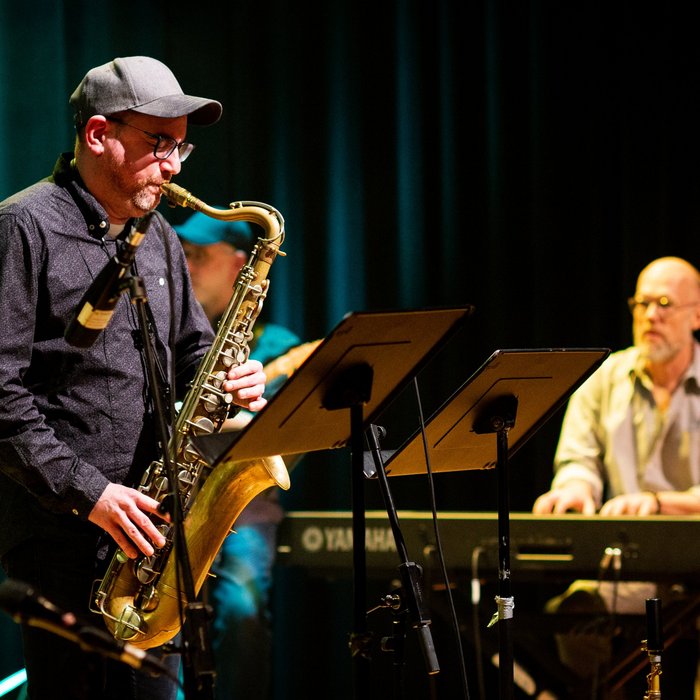 Saxofonist Tobias Schöpker mit geschlossenen Augen, im Hintergrud Stefan Holweg am E-Piano