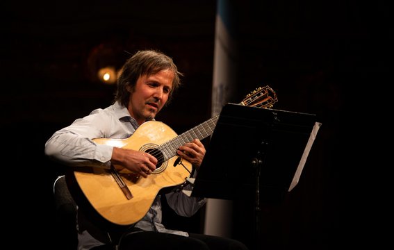 Gitarrenlehrer Marc Kassel mit Gitarre auf der Bühne