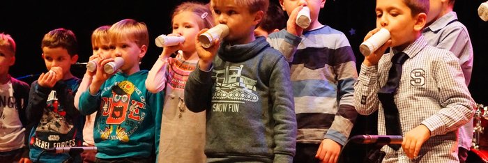 Kleinkinder mit selbstgebastelten Kazoos aus Klopapierrollen