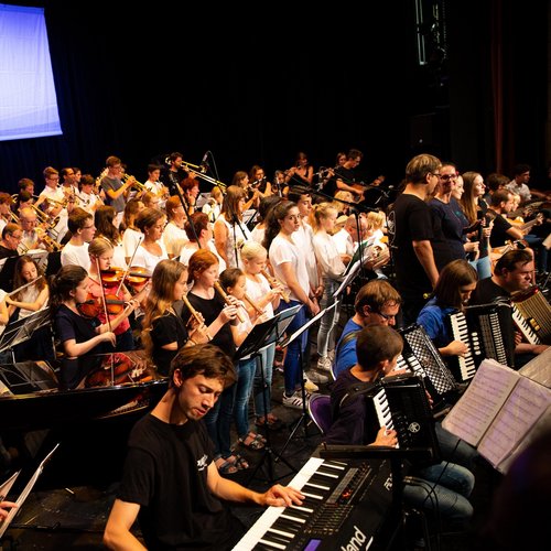 Diverse Schüler, Kinder und Erwachsene spielen im großen Orchester Jahreskonzert der Musikschule Fürth