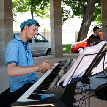 Junger Mann mit körperlicher Behinderung am E-Piano