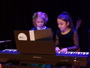 Zwei Mädchen spielen vierhändig an einem E-Piano