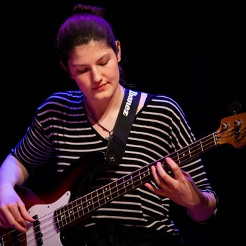 Junge Frau mit E-Bass