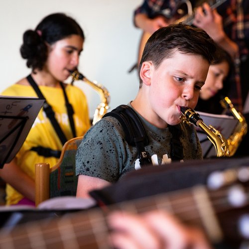 Kinder üben Saxophon spielen mit Notenständer