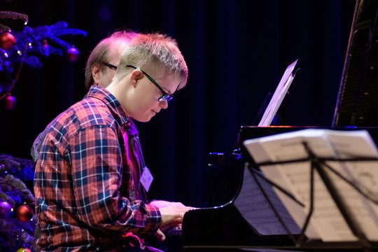 Junge mit Downsyndrom spielt Klavier