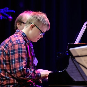 Junge mit Down-Syndrom am Klavier