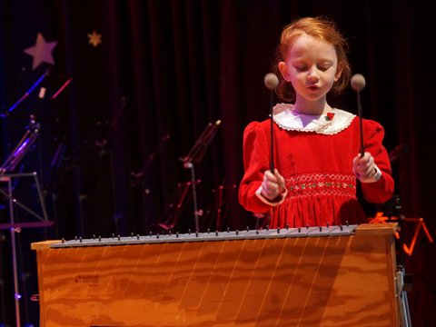 Mädchen im Grundschulalter spielt Metallofon