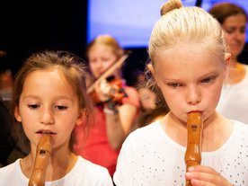 Zwei Mädchen im Grundschulalter spielen Blockflöte