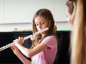 Mädchen spielt mit einer Kinder-Querflöte