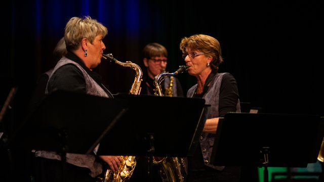 Zwei ältere Frauen spielen sich mit Saxofonen an