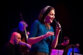 Sängerin Susanne Schönwiese singt, im Hintergrund eine Band