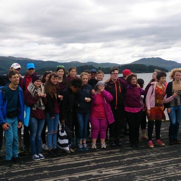 Gruppenbild: Jugendliche mit und ohne Behinderung stehen auf einem Holzsteg am Wasser