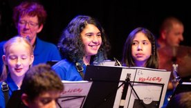 Lachende Kinder und Jugendliche mit Festival-T-Shirts auf der Bühne