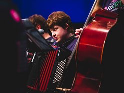 Mädchen spielt mit geschlossenen Augen Akkordeon