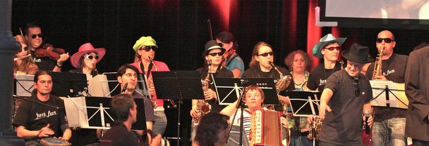 Die Band Just Fun, einige Musiker:innen tragen bunte Hüte und Sonnenbrillen
