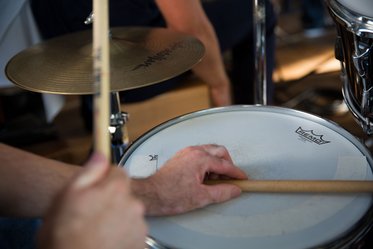 Hände mit Drumsticks spielen Schlagzeug