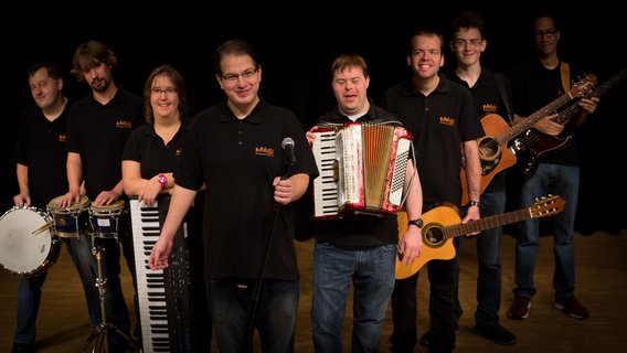 Bandfoto der Band Vollgas, die Musiker:innen haben ihre Instrumente in der Hand und sind wie ein V aufgestellt.