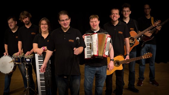Bandfoto der Band Vollgas, die Musiker:innen haben ihre Instrumente in der Hand und sind wie ein V aufgestellt.