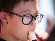 Junge mit Downsyndrom spielt Blockflöte