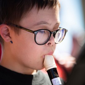 Junge mit Downsyndrom spielt Blockflöte