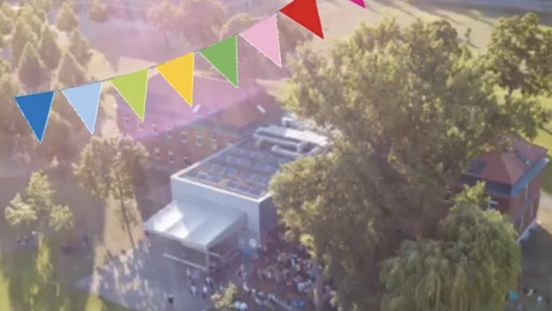 Luftaufnahme des Musikschulgebäudes. Darüber eine bunte Girlande und der Schriftzug 35 Jahre Musikschule Fürth