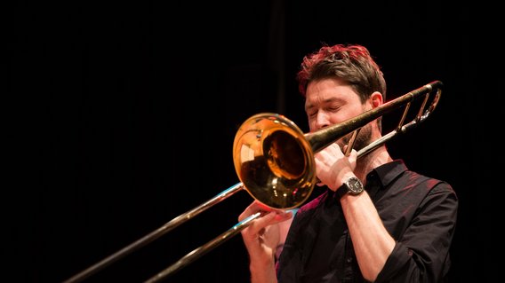 Lehrer Christoph Müller spielt mit geschlossenen Augen Posaune