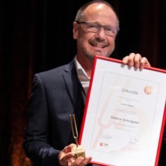 Robert Wagner mit der goldenen Stimmgabel des VdM und der dazugehörenden Urkunde