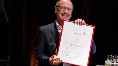 Robert Wagner mit der goldenen Stimmgabel des VdM und der dazugehörenden Urkunde