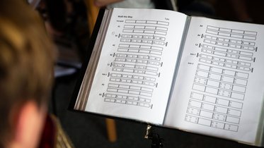 Notenblatt, auf dem Musik in Buchstaben notiert ist